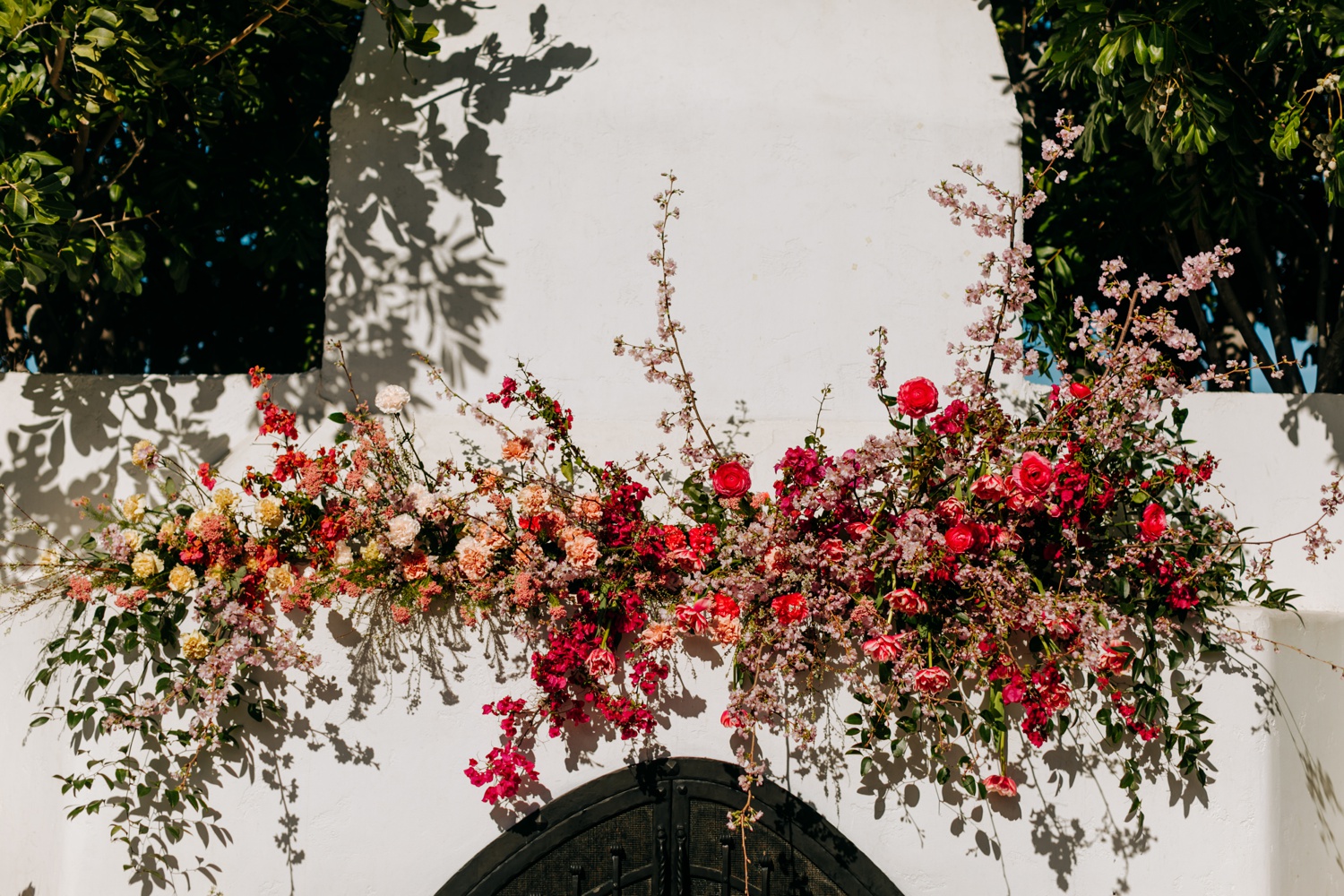Casino San Clemente wedding ceremony with bright pink florals and bohemian design