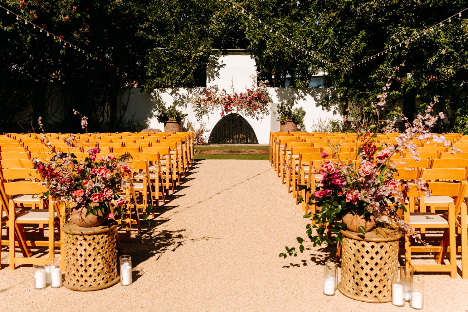 Casino San Clemente wedding ceremony with bright pink florals and bohemian design