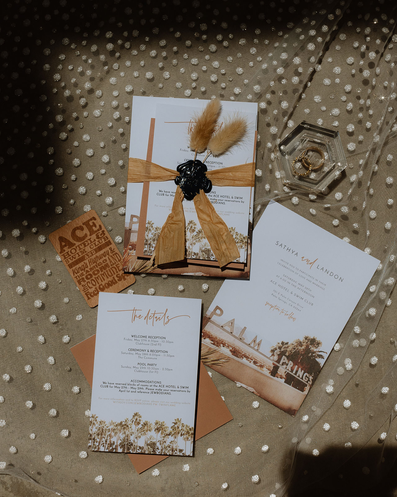 Gorgeous flatlay shot of invitations and wedding rings on a textured background.