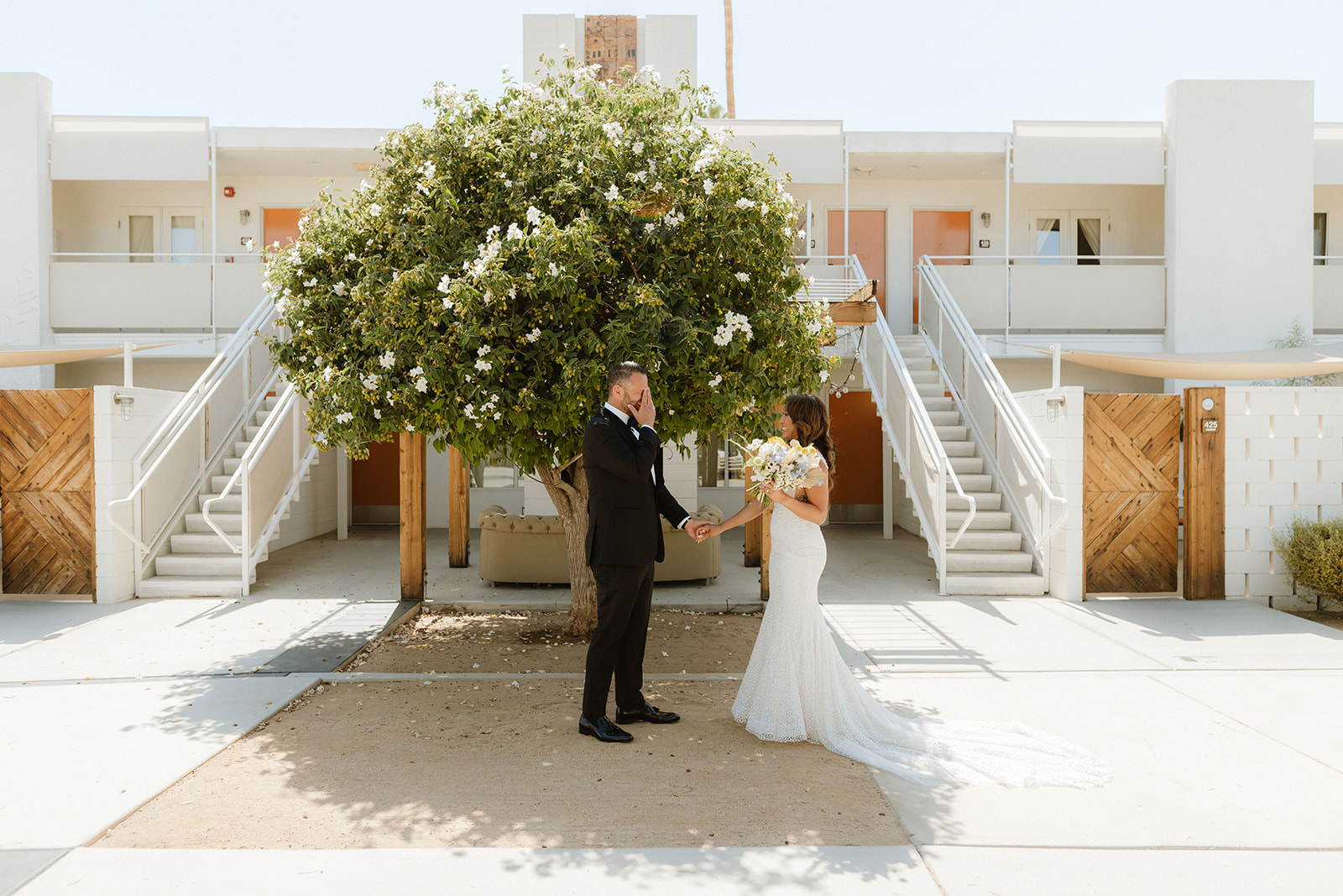 A wedding couple shares a first look together at their poolside palm springs wedding.