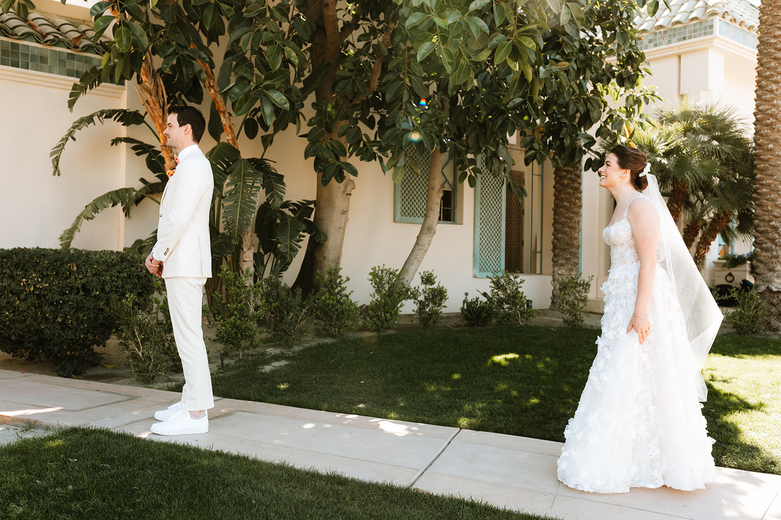 A wedding couple shares a first look together at their poolside palm springs wedding.